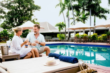 Couple with drinks by the pool, Novotel Fiji, Fiji. 