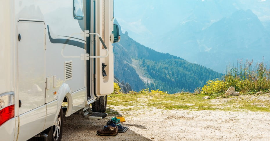Motorhome with mountain cliff view.