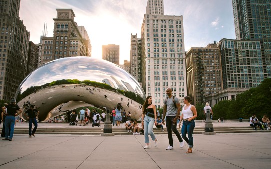 People walking along and taking photos of The Bean in Chicago, USA