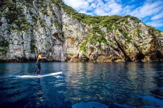 A Paddleboarder enjoys Poor Knights Islands, New Zealand. 