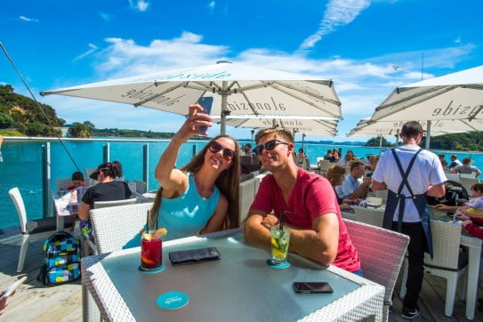 Couple taking selfie during lunch at Paihia waterfront, Northland, New Zealand. 