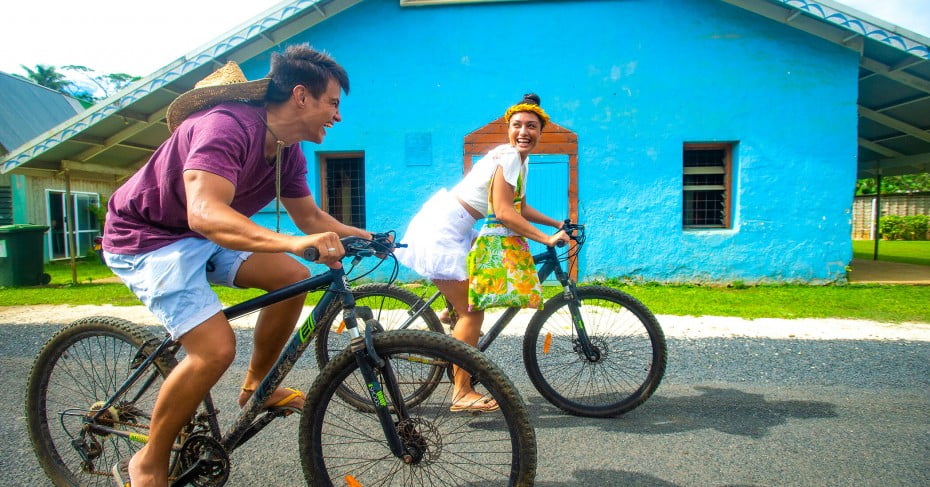 Couple biking in Rarotonga, Cook Islands. 