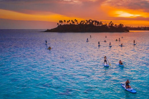 Paddleboarders in the sunset, Rarotonga, Cook Islands. 