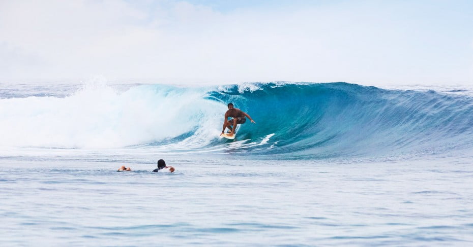 Surfer riding waves in Tahiti