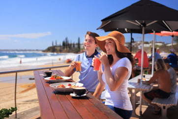 Couple eating at Alex Heads Surf Club, Sunshine Coast, Australia. 