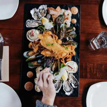 table full of different type of oysters and seafood